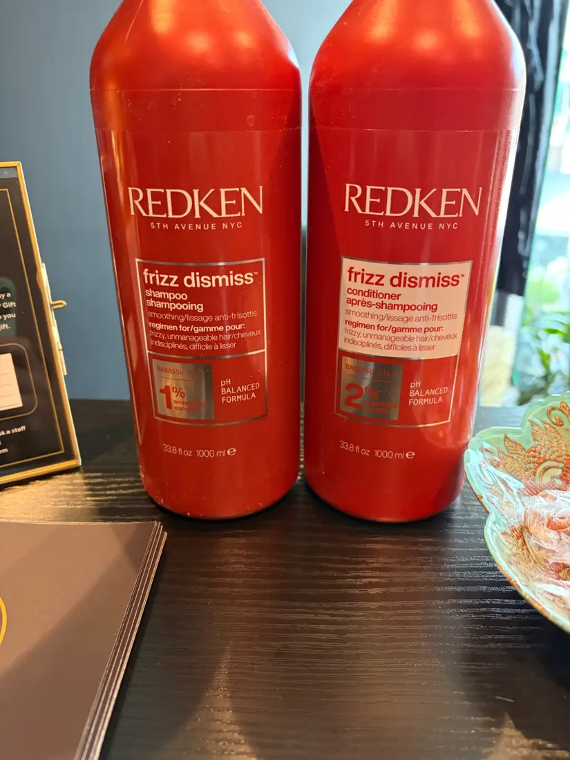 Close-up of Redken Frizz Dismiss shampoo and conditioner bottles